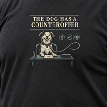 Load image into Gallery viewer, Illustrative close-up of The Dog Has a Counteroffer graphic on black shirt fabric