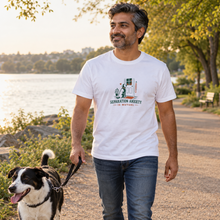 Load image into Gallery viewer, Separation Anxiety Is Mutual dog lover T-shirt in White, front view on a man walking a dog by a lake; illustrative lifestyle mockup