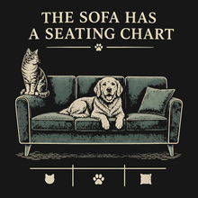 Load image into Gallery viewer, Digital artwork detail for The Sofa Has a Seating Chart pet lover T-shirt; exact lettering, dog, cat, and sofa illustration.